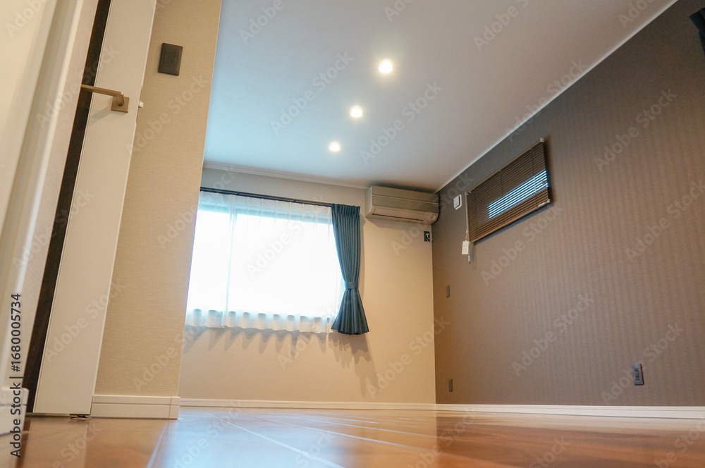 窓から光差し込むシンプルな広々洋室空間